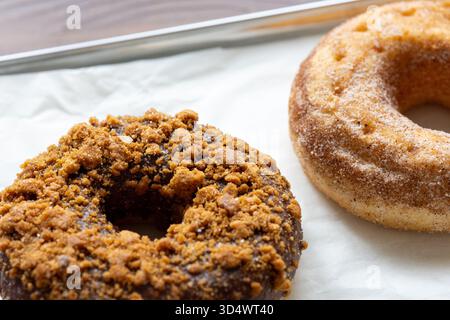 Close-Up of Chocolate-Covered and Biscuit-Topped Donuts Displayed on a Metal Tray Stock Photo