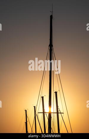 Sailboat masts silhouetted against sunset Stock Photo - Alamy