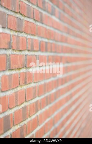 Modern red brick wall with leading lines from sharp to blurred Stock Photo