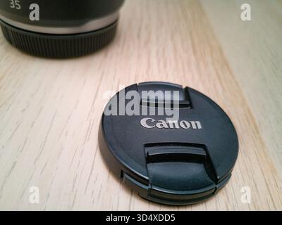 Wroclaw, Poland - September 9 2024: Black lens cap for a Canon mirrorless RF lens, featuring the embossed Canon logo, providing essential protection f Stock Photo