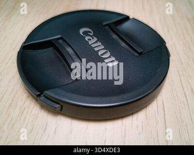 Wroclaw, Poland - September 9 2024: Black lens cap for a Canon mirrorless RF lens, featuring the embossed Canon logo, providing essential protection f Stock Photo