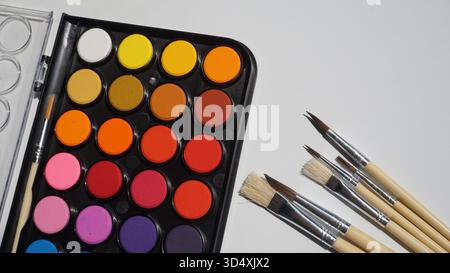 Palette of watercolors and paintbrushes on white background Stock Photo