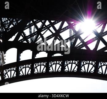 Sun shining through Eiffel Tower. Paris, France. Black white historic photo. Stock Photo