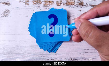 Hand Writing Question Mark: Stack of Blue Sticky Notes with Marker Pen Stock Photo