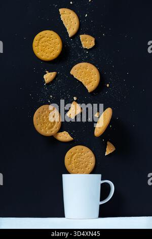 Rich Tea biscuits falling in to tea cup Stock Photo