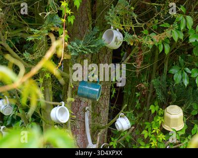 Various mugs and a flower pot hanging on a tree. Stock Photo