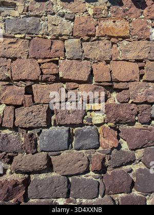 Rustic Stone Wall Texture with Mixed Volcanic Rocks Stock Photo