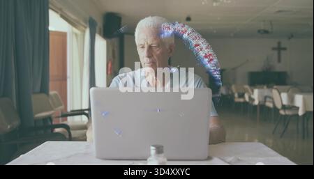Sitting senior man using laptop at church hall table, in light polo, salt shaker, crucifix Stock Photo