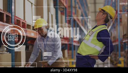 Scanning two workers wearing yellow hard hats checking boxes in warehouse racks with HUD overlays Stock Photo