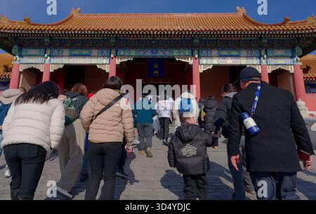 Inside the Forbidden City, visitors climb stone steps toward an ornate gate Stock Photo