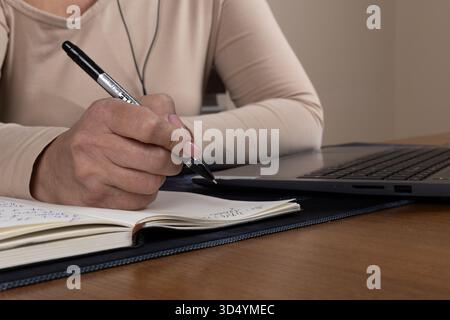 The journalist is diligently taking notes for an upcoming news report Stock Photo