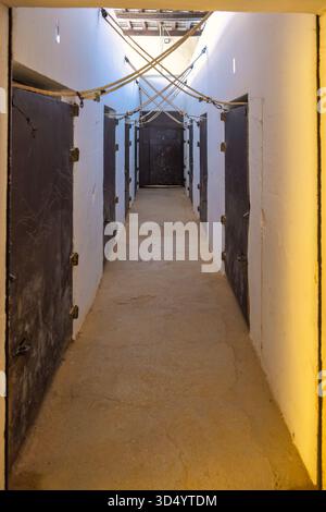 Ronda, Spain - September 4, 2024: The Plaza de Toros, a bullring in Ronda. Long corridor with dark doors and overhead ropes in an old building. Stock Photo