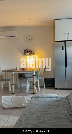 Cozy dining corner with warm evening light in modern home. Domestic interior, comfort, and calm everyday lifestyle with cozy details. Stock Photo