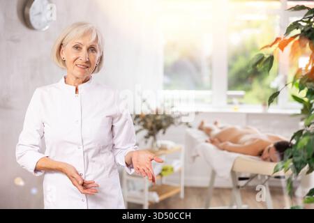 Elderly woman masseuse posing in spa salon Stock Photo