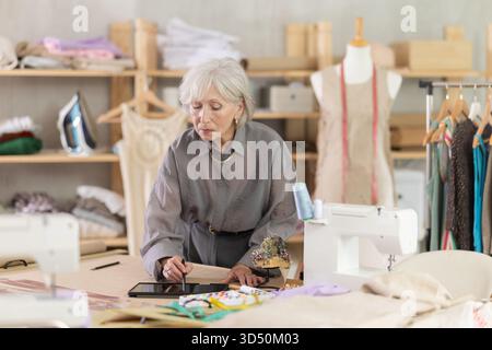 Woman dressmaker makes pattern using tablet Stock Photo
