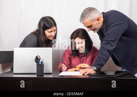 Brainstorming between three colleagues. The two women and the man are about forty years old and are of Italian origin Stock Photo
