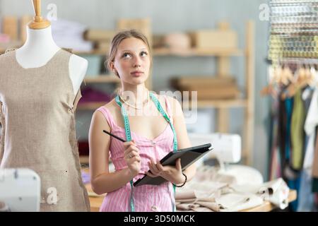 Woman dressmaker makes pattern using tablet Stock Photo
