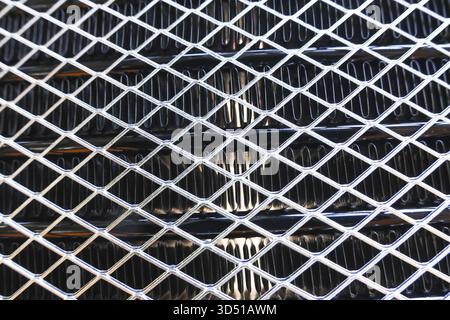 Close up of an industrial metal grate with diamond pattern. Abstract background texture showing strong, rigid, and metallic surface perfect for indust Stock Photo