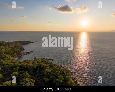 Drone captures bright sun setting over calm Mediterranean horizon Stock Photo