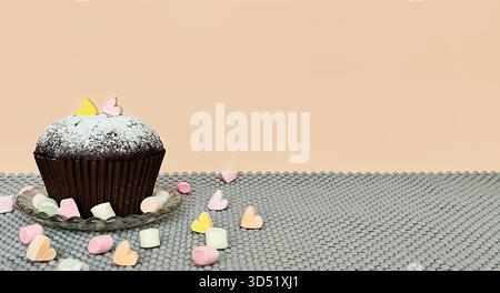 Chocolate cupcake and marshmallows on a beige gray background. Space for text. Stock Photo