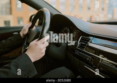 Young Adult Man Driving Car with Hands on Steering Wheel Stock Photo