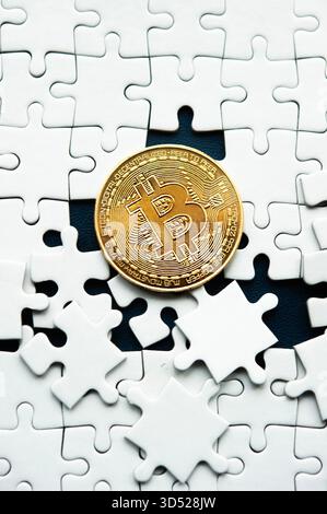 Gold Bitcoin coin surrounded by white puzzle pieces expressing uncertainty in digital finance Stock Photo