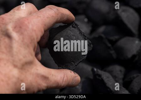 charcoal compressed from crumbs is obtained under pressure and used to cook food on the grill, black charcoal in briquettes for barbecues and grills Stock Photo