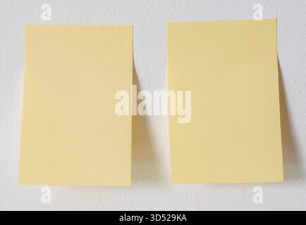 Two sticky notes on white wall Stock Photo