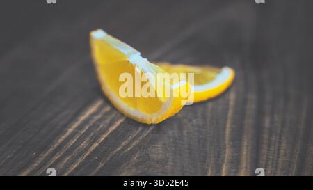 Cut lemon segments on a wooden cutting surface in soft natural light. A crisp, uplifting citrus composition perfect for food photography Stock Photo