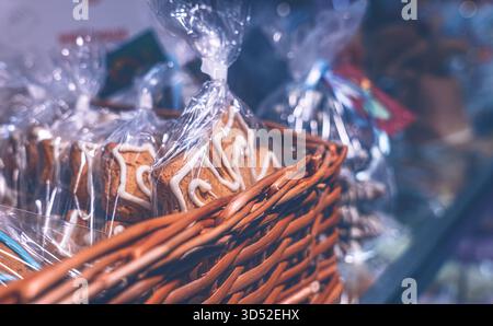 Fresh holiday cookies in a transparent package and a wicker basket on a store display Stock Photo