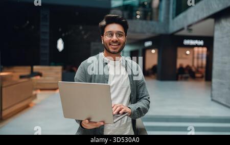energetic male team leader in casual attire demonstrating innovation and teamwork in workspace Stock Photo