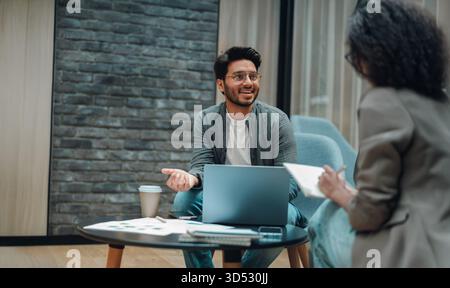 team members discussing project details, male and female engaged in productive brainstorming session Stock Photo