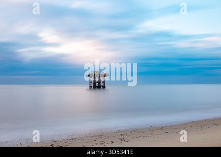 Derelict cooling platform off Sizewell nuclear power station captured in soft morning light with long-exposure sea and sky Stock Photo