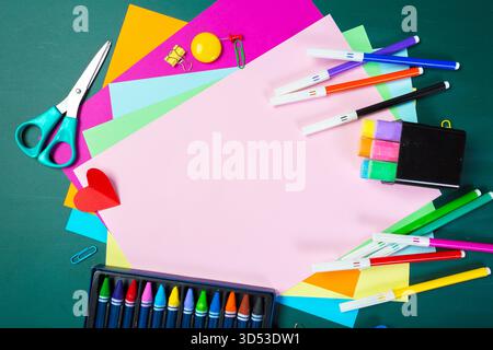 Colorful art supplies and craft materials arranged on a green workspace for creative projects Stock Photo