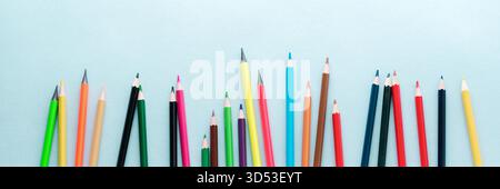 Colored pencils, scissors, notebook, ruler, pen, eraser, sharpener and more in glass. School and office stationery on light blue background. Concept back to school. Top view. Stock Photo
