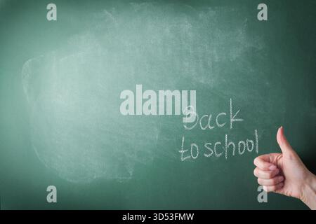 Female teachers hand writing on school board back to school white chalk. Concept back to school. Mock up for design. Copy space. Education Concept. Stock Photo