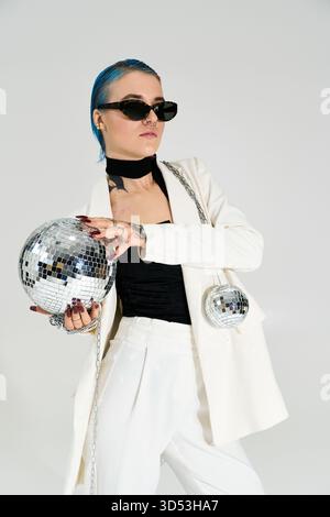 A beautiful young woman embraces the festive winter spirit while holding glittering disco balls. Stock Photo