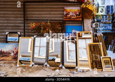 Rabat, Morocco – April 19, 2025: a traditional Moroccan market stall displays decorative mirrors, framed artwork, and Islamic calligraphy. The mirrors Stock Photo