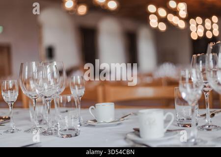 Majestic medieval castle banquet hall with long wooden tables, chandeliers, and stone walls illuminated by warm candlelight, evoking the atmosphere of Stock Photo