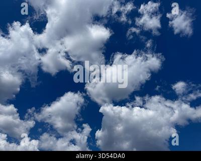 Puffy clouds in blue sky Stock Photo