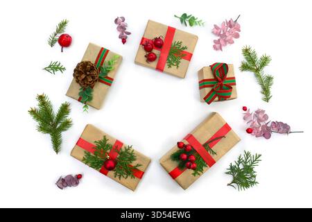 Christmas decoration. Frame of gift boxes, Christmas tree branch, red berries, pine cones on a white background. Stock Photo