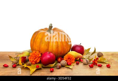 Pumpkin, yellow pears, apples and autumnal colorful maple leaves on wooden table on a white background with space for text Stock Photo