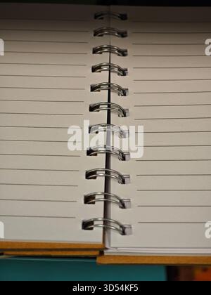 A spiral notebook lies open with blank pages, inviting creativity and ideas. The clean lines and simplicity create a space for writing, drawing, or pl Stock Photo