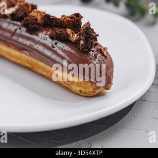 Food, Eclair with Chocolate Cream and Hazelnuts closeup Stock Photo