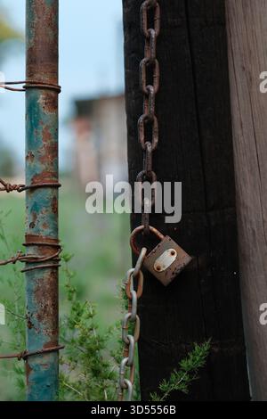 Rusty Padlock and Chain on Weathered Gate Post Outdoors Stock Photo