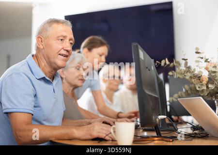 Enthusiastic senior man attending computer class for older adults Stock Photo