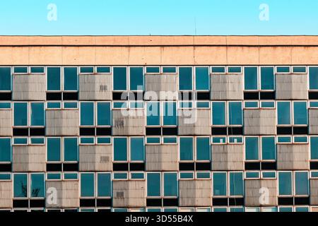 Geometric facade of a modern building with repeating windows and panels. Stock Photo
