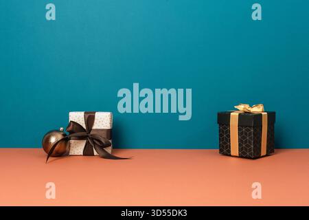 Two gift boxes and brown ornament on blue and orange background with copy space. Merry Christmas concept. Stock Photo