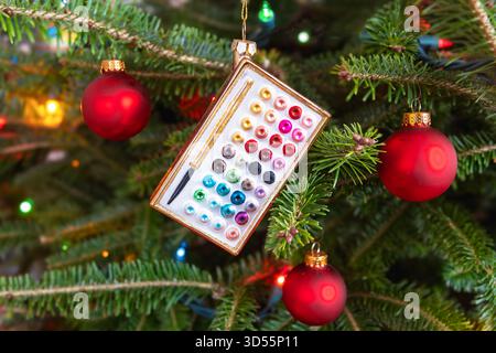 Christmas ornament in the form of a watercolor palette. hanging in a Christmas tree. Stock Photo