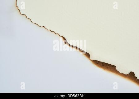Bangkok, Thailand.A piece of paper is torn, exposing a charred edge that creates a contrast with the lighter surface. Stock Photo